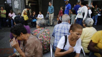 Venezolanos esperan en la entrada de un supermercado de Caracas, Venezuela, el 23 de agosto.