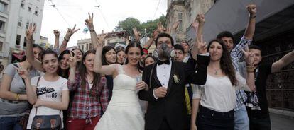 Una pareja de reci&eacute;n casados con un grupo de manifestantes en Estambul.