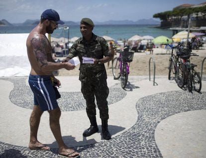 Un soldado reparte folletos informativos sobre el virus del Zika en la playa de Copacabana.