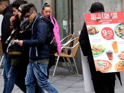 Una persona anuncia un restaurante en el centro de Madrid.