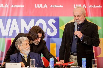 El fotógrafo Stuckert coloca una carpeta frente al candidato presidencial en presencia del excanciller Celso Amorim, el pasado 29 de agosto en São Paulo. 