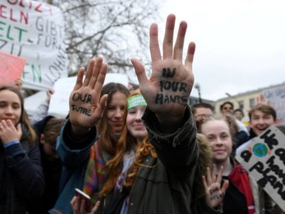 "Nuestro futuro en tus manos" es el eslogan que tienen dos jóvenes pintado en sus manos durante una manifestación en Berlín (Alemania).