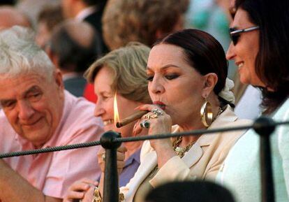 Sara Montiel enciende un puro en una corrida de la Feria de Abril de Sevilla de 1999.