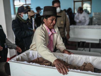 Una mujer llora ante los restos de su padre.