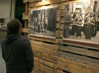 Una joven contempla dos de las fotografías del barrio de Egia expuestas en la vieja fábrica de tabaco.