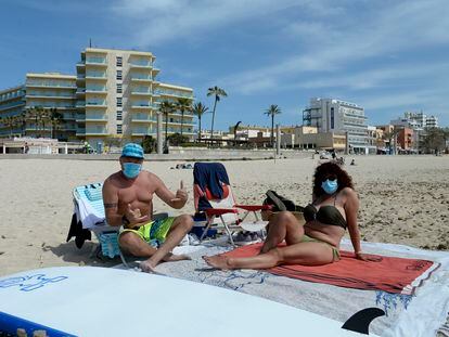 Bañistas con mascarilla, el martes en una playa de Mallorca.