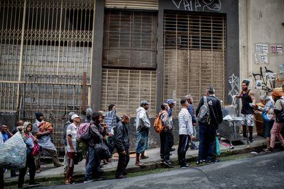 Personas sin techo hacen cola para recibir un plato de comida en una calle de São Paulo (Brasil), el 21 de octubre de 2022.