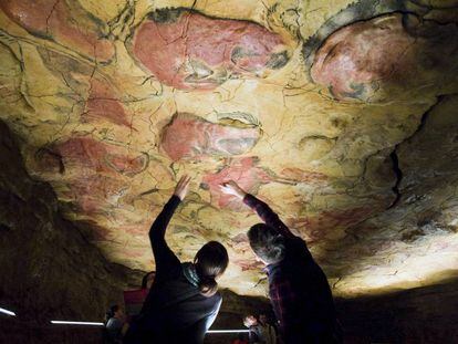 Unos turistas observan las pinturas rupestres en la réplica de las Cuevas de Altamira, situada en la localidad cántabra de Santillana del Mar. 