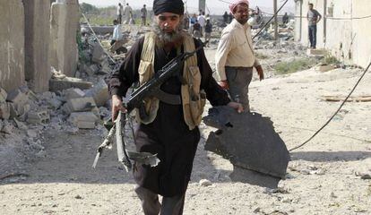 Un miembro del EI lleva un pedazo de un avi&oacute;n ca&iacute;do en Raqa (Siria).