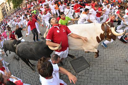 Un toro de la ganadería de Miura arrolla a un mozo en el octavo y último encierro de Sanfermines, este viernes en Pamplona.