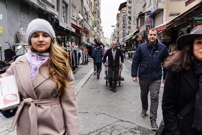 Un porteador turco transporta edredones y ropa de cama a una de las viviendas alquiladas por el proyecto Kovcheg para acoger a rusos que han huido de su país por el deterioro de la situación política, pero tienen dificultades para acceder a sus fondos por las sanciones.