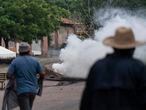 Habitantes de Aguililla (Michoacán) corren a resguardarse de una bomba de gas lacrimógeno lanzada por el Ejército durante una manifestación para exigir la reapertura de la carretera que conecta ese municpio con Apatzingán, el 7 de julio de 2021.