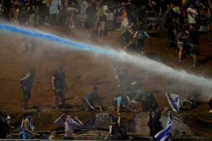La policía israelí usan cañones de agua para dispersar a los manifestantes durante la protesta contra la reforma judicial de Netanyahu en Tel Aviv, este lunes. 