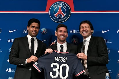 El presidente qatarí del París Saint-Germain, Nasser Al-Khelaifi (izquierda), y el director deportivo del equipo, Leonardo Nascimento de Araujo (derecha), posan con Messi mientras este sostiene su camiseta con el número 30 durante una rueda de prensa en el estadio del Parc des Princes.