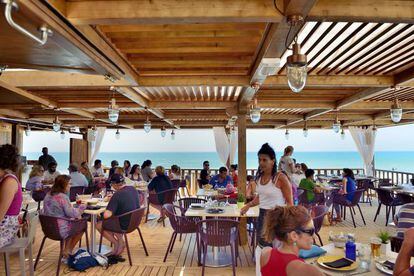 El Atenas Playa, en La Barrosa, tiene camas balinesas y bajo su pérgola de madera sirven salmorejo y presa de jabugo.