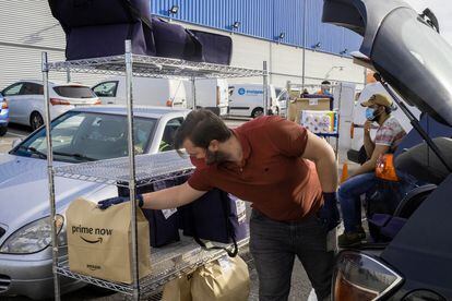 Un repartidor de Amazon carga los paquetes en su automóvil antes de partir desde el almacen de la empresa en el municipio de Coslada, junto a Madrid.