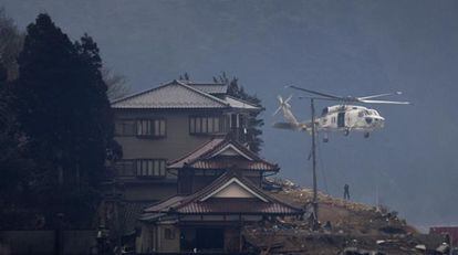 Un helicóptero de rescate ayuda a una víctima del terremoto de la ciudad de Kesennuma