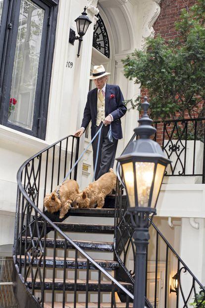 El escritor Gay Talese saliendo con sus perros del edificio que posee en Manhattan. En la ventana, un ramillete de claveles rojos a juego con el pañuelo que lleva en la pechera.
