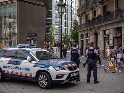 Dos agentes de seguridad ciudadana de los Mossos d'Esquadra vigilan en el Paseo de Gràcia en plena zona de afluencia turística.