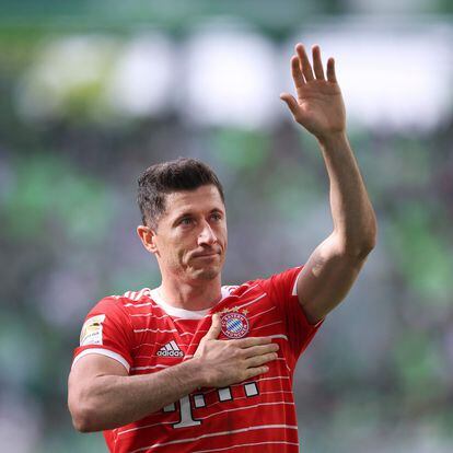 Bayern Munich's Polish forward Robert Lewandowski greets and holds a hand on his heart after the German first division Bundesliga football match VfL Wolfsburg v Bayern Munich in Wolfsburg, northern Germany, on May 14, 2022. (Photo by Ronny Hartmann / AFP) / DFL REGULATIONS PROHIBIT ANY USE OF PHOTOGRAPHS AS IMAGE SEQUENCES AND/OR QUASI-VIDEO
