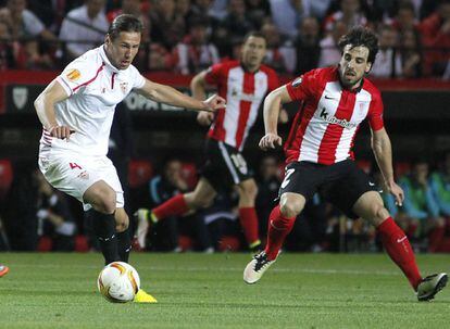 El centrocampista polaco del Sevilla Grzegorz Krychowiak (i) trata de marcharse del centrocampista del Athletic de Bilbao Beñat Etxebarria (d).
