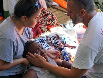 Dos sanitarios atienden a una migrante en el 'Open Arms', este domingo.