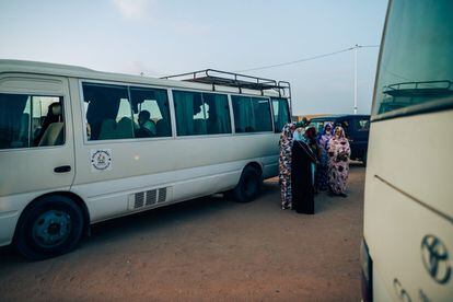 Un grupo de anfitrionas espera junto a los autobuses la llegada de los visitantes para distribuirlos en sus alojamientos, sus propias casas, en Bojador.