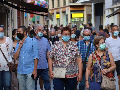 Gente por la calle con mascarilla en Sitges.