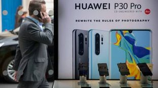 Un ciudadano británico camina al lado de una tienda que ofrece móviles Huawei en el centro de Londres, el pasado abril.