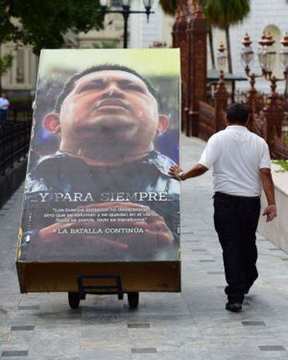 Operarios retiran ayer carteles del expresidente venezolano Hugo Chávez en la Asamblea.