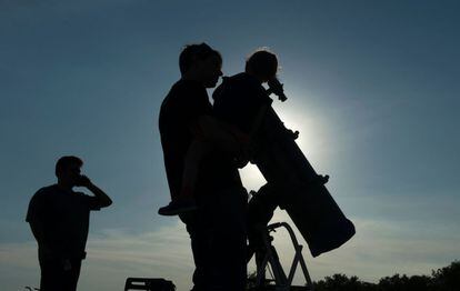 Un padre y su hijo miran a través de un telescopio durante un festival de astronomía en Washington, Estados Unidos.