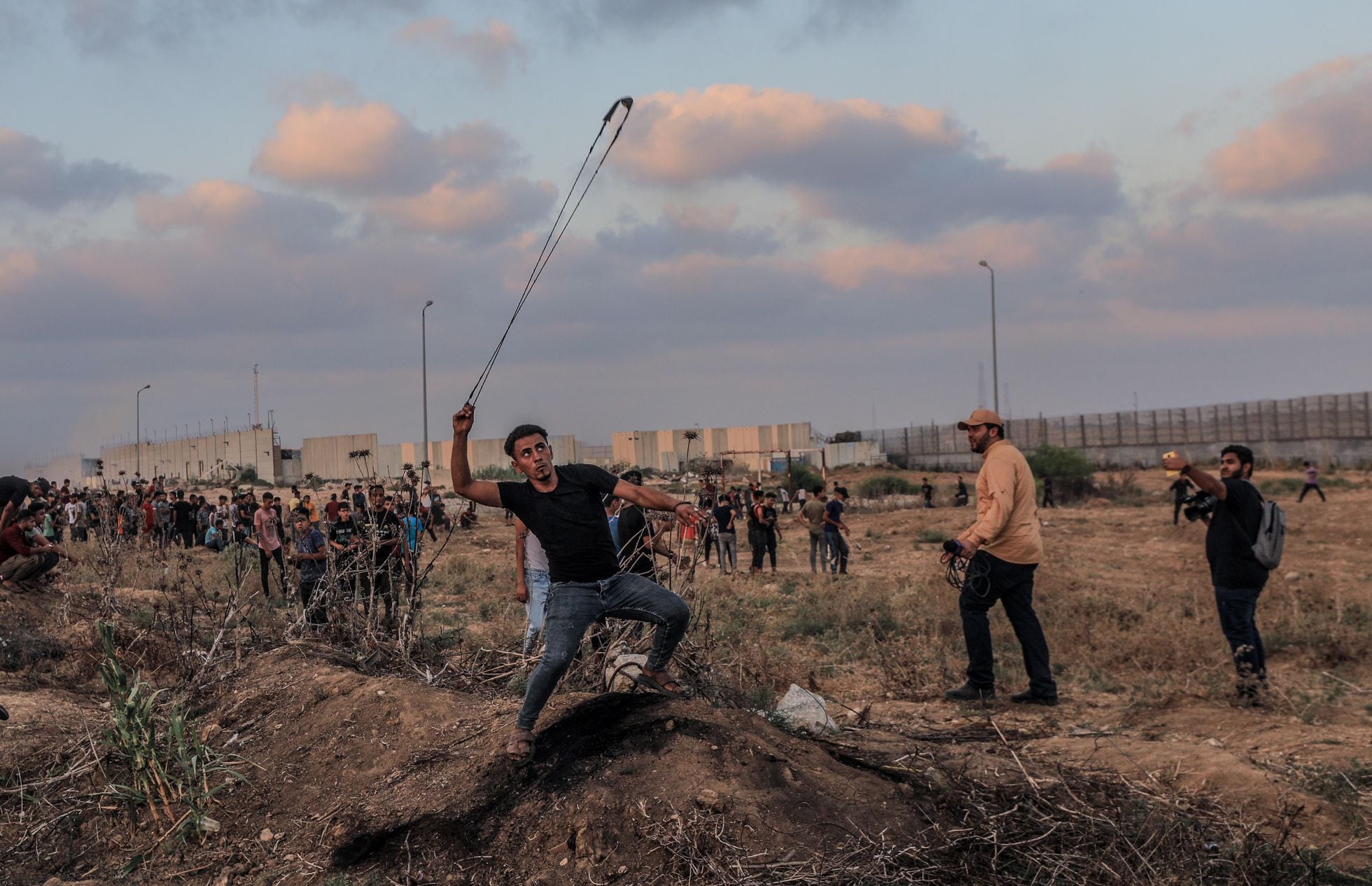 Un manifestante palestino arroja piedras a las fuerzas israelíes, el sábado en la frontera entre Israel y Gaza.