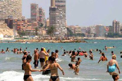 Un gran número de bañistas disfrutan de las aguas del Mediterráneo en la localidad de Postiguet ante la ola de calor.