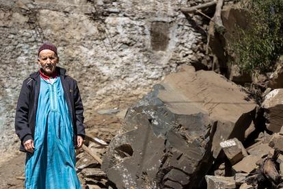 Taib Ait-Uzdut (65 años) posa delante de una de  rocas que casi aplasta su casa. Él y su mujer consiguieron salir por sus propios pies.  