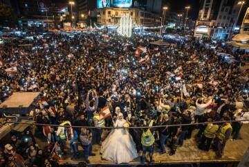 Una pareja de recién casados festeja su boda en la plaza Al Nur de Trípoli (al norte de Líbano) entre los vítores de los manifestantes y al ritmo de música 'techno'.