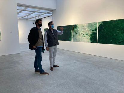 El artista Hugo Fontela enseña a un visitante la obra 'River X' de su muestra 'The River', expuesta en la galería Marlborough.
