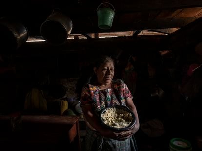 Una mujer sostiene un cuenco lleno de masa de maíz en su hogar, ubicado en la aldea de Tuilelen, en Comitancillo, Guatemala, el 2 de mayo de 2022.