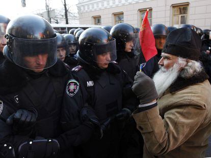 Un manifestante sostiene una bandera frente a la l&iacute;nea de la polic&iacute;a durante una manifestaci&oacute;n en Kiev esta ma&ntilde;ana en apoyo a la integraci&oacute;n europea. 