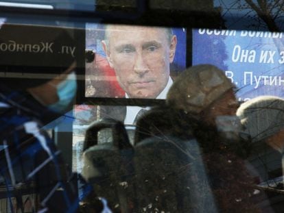Un autobús pasa ante una pantalla con la imagen de Putin, el viernes en Simferópol, Crimea.