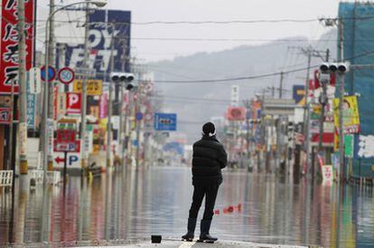 Un hombre mira la destrucción en un área cubierta de agua en Ishinomaki, en la prefectura de Miyagi, Japón.