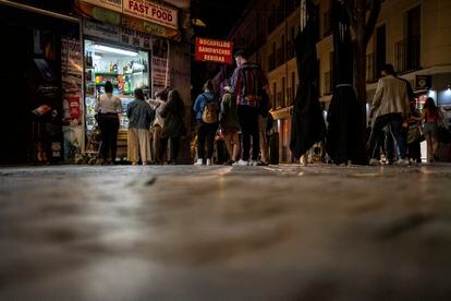 Jóvenes hacen cola para comprar en una tienda de Madrid, en la madrugada del 9 de mayo, tras acabar el estado de alarma.