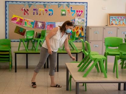 Una profesora prepara un aula para los alumnos que se reincorporan a clase tras el confinamiento, el jueves en Haifa.