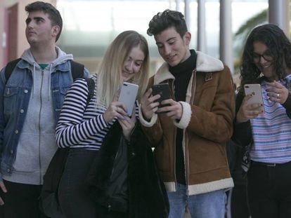 Un grupo de jóvenes interactúa con sus móviles.