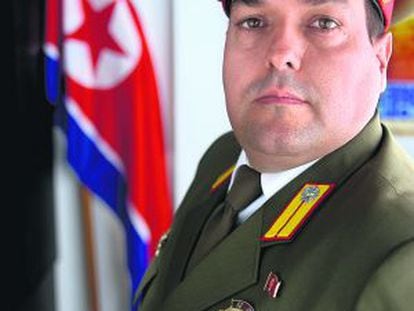 Alejandro Cao de Benós, fotografiado en Salomó (Tarragona), donde vive, con su uniforme y junto a la bandera de Corea del Norte.