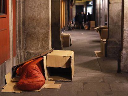 Una persona sin hogar durmiendo en los soportales de la plaza Mayor de Madrid.