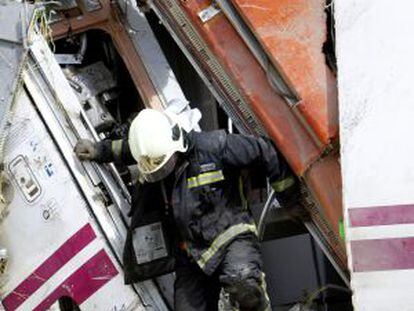 Un bombero trabaja en uno de los vagones del tren siniestrado en Santiago.