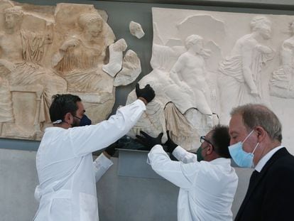 Los conservadores del Museo del Acrópolis, en Atenas, colocan un fragmento del friso del Partenón, dejado en depósito en enero de 2022 por el Museo Salinas de Palermo, que lo exponía desde el siglo XIX.
