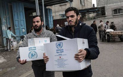 Refugiados palestinos recogen paquetes con ayuda de la ONU en Jan Yunis (Gaza).