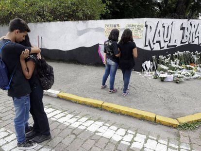Estudiantes se abrazan afuera de la escuela pública un día después del tiroteo. Los alumnos colocaron una ofrenda en honor a las víctimas. 
 