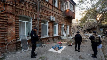 Tras efectivos de los servicios de emergencia ucranios junto al cadáver de un hombre tras el bombardeo de un edificio residencial en Mikolaiv.